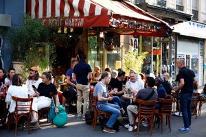 People sit on the terrace of a cafe in Paris
