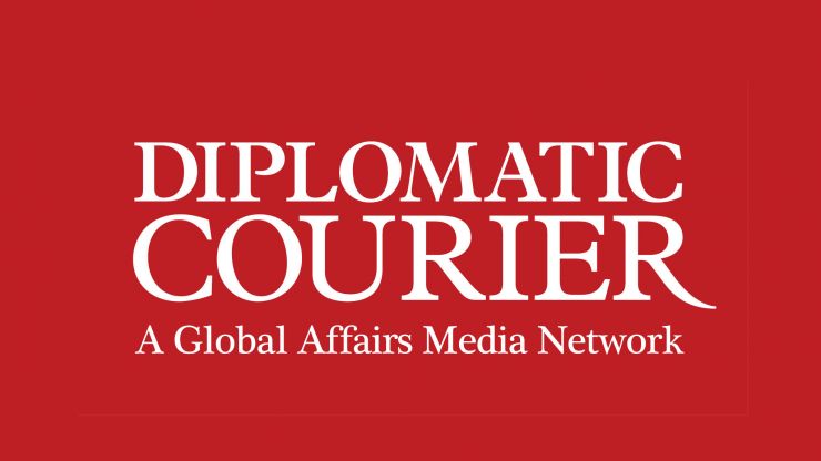A logo of the Diplomatic Courier on a red background