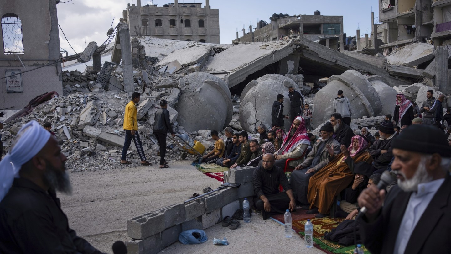 people praying by rubble