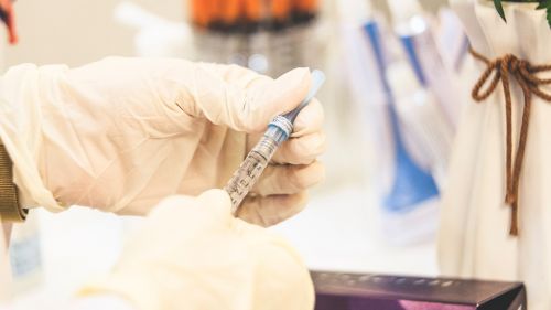a medical professional prepares a vaccine syringe 