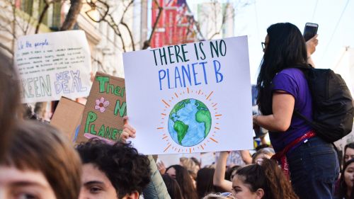 Amid a crowd of people, someone holds a sign that says "There is no Planet B"