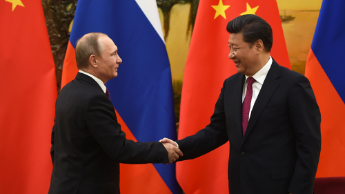 Against a backdrop of Russian and Chinese flags, Russian President Vladimir Putin shakes hands with Chinese President Xi Jinping at the end of a joint press briefing in Beijing's Great Hall of the People.