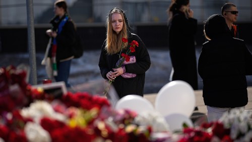 Girl lays flowers at Crocus City Hall in Russia