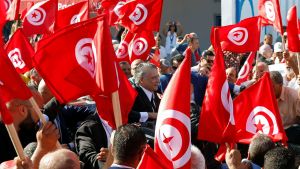 Tunisian presidential candidate Nabil Karoui greets supporters from a car during an election campaign event.