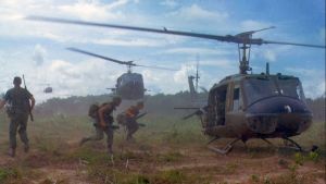 Military running to helicopters during the Vietnam War.