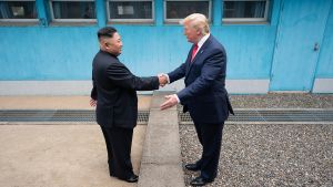 Donald J. Trump shakes hands with Kim Jong Un