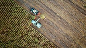 Aerial view of a truck harvesting a crop on a farm