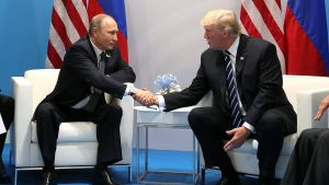 Vladimir Putin, left, and Donald Trump shake hands