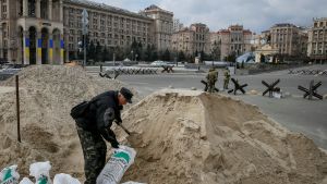 A man prepares barriers made of sandbags as members of the Ukrainian Territorial Defence Forces guard in central Kyiv