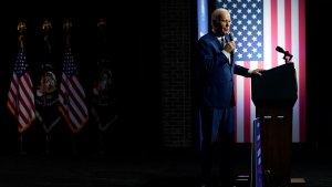 Joe Biden speaks in front of an American flag