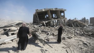 Palestinians inspect the destruction left by the Israeli air and ground offensive