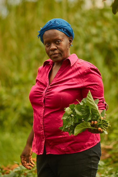 Lutomia shows off some of her produce grown using skills from SAWBO videos.