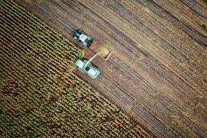 Aerial view of a truck harvesting a crop on a farm