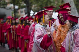 A group of people in red graduation caps and gowns