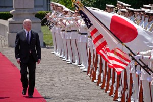 Biden walks by a Japanese flag