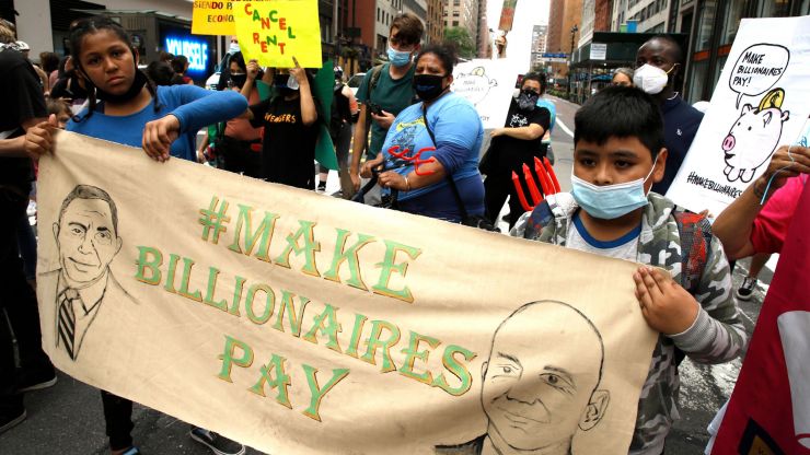 Children protesting and holding a sign that says "Make Billionaires Pay."