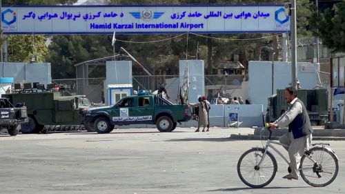 Man on bicycle in front of Hamid Kerzal International airport in Kabul