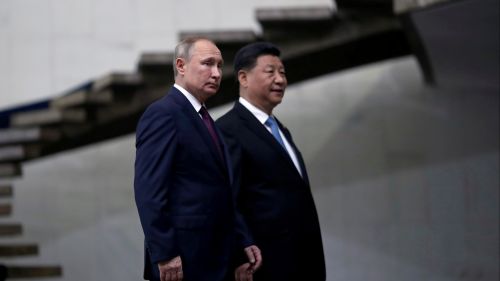 Xi Jinping and Putin walking near stairs.