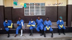 Health workers rest outside a quarantine zone at a Red Cross facility in the town of Koidu, Sierra Leone