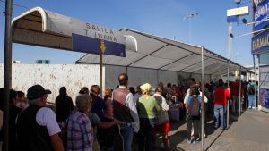 People wait in line at the US-Mexico border. 