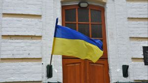 Flag of Ukraine waving in front of a wooden door.