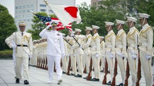 Chief of Naval Operations Adm. Jonathan Greenert salutes as he passes the American and Japanese flags during a full honors ceremony at the Japanese Ministry of Defense