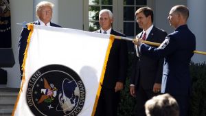 President Donald Trump watches with Vice President Mike Pence and Defense Secretary Mark Esper as the flag for U.S. Space Command is unfurled