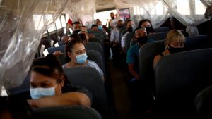 People in surgical masks sit on a bus