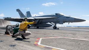 U.S. Navy Lt. Kristin Hope, from Ogden, Utah, signals to launch an F/A-18E Super Hornet from Strike Fighter Squadron (VFA) 195 from the flight deck 