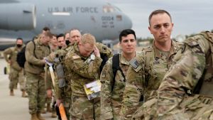 Military personnel from the 82nd Airborne Division and 18th Airborne Corps board a C-17 transport plane for deployment to Eastern Europe