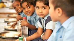 Students eat a midday meal in India