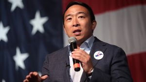 Andrew Yang speaks in front of an American flag