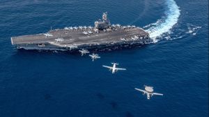 Multiple aircraft from Carrier Air Wing (CVW) 5 fly in formation over the Navy's forward-deployed aircraft carrier USS Ronald Reagan.
