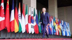 Joe Biden walks by world flags