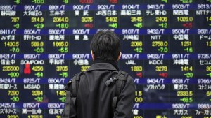 A person looks at a large screen of the Japanese stock market